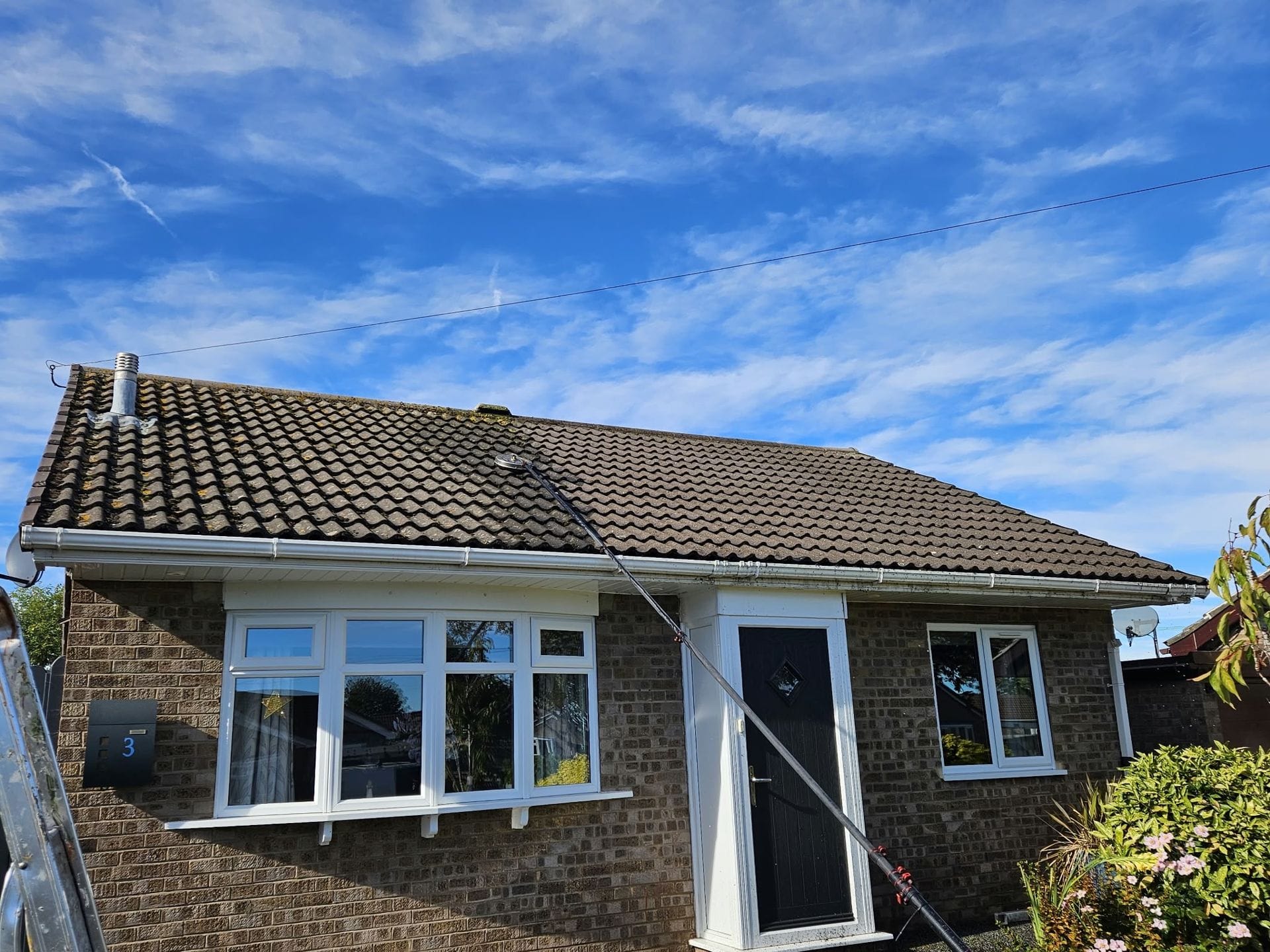 Professional applying moss treatment biocide to patio in Lincolnshire